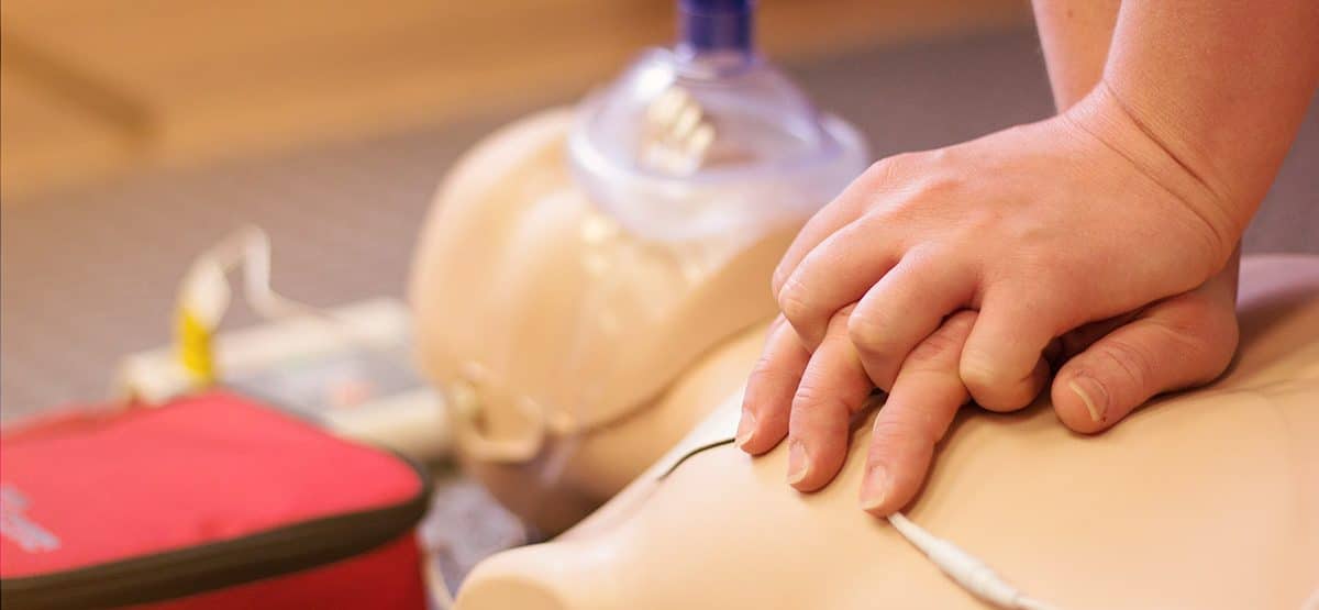 CPR is performed on a training dummy with an oxygen mask during a training session